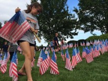 Girl Scout Kelly Thorpe, 13, places American flags in the shape of a heart to honor 9/11 victims at McGuinness Funeral Home in Washington Township on Sept. 10, 2014 (Michelle Caffrey | South Jersey Times)