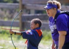CHRIS NEAL/THE CAPITAL-JOURNAL Left: Tami Breymeyer, of Wamego, cheers on her 6-year-old son, Caleb, as he launches an arrow at a target. Center: Boy Scout D.J. Kester, of Hoyt, gets set to launch his water rocket into the air at the recent Cub Scout Adventure Day. Right: Brandon Griffin, far right, of Topeka, helps his son, Jax, aim a BB gun at a target on the firing range.